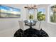 Bright dining area with a table and chairs, a modern light fixture and beach themed television display at 7118 Hawks Harbor Cir, Bradenton, FL 34207