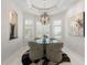 Elegant dining room with modern chandelier, round glass table, and sophisticated decor at 7118 Hawks Harbor Cir, Bradenton, FL 34207