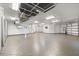 View of the spacious garage featuring high ceilings, custom storage, epoxy flooring and three garage doors at 7118 Hawks Harbor Cir, Bradenton, FL 34207