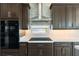 Modern kitchen featuring stainless steel hood, cooktop, and ample counter space at 7118 Hawks Harbor Cir, Bradenton, FL 34207