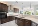 Kitchen featuring dark cabinetry, stainless steel appliances, and views to adjacent dining area at 7118 Hawks Harbor Cir, Bradenton, FL 34207
