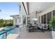 A covered patio with an outdoor seating area, television and a view of the pool at 7118 Hawks Harbor Cir, Bradenton, FL 34207