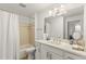 Well-lit bathroom with a large mirror, white cabinets, and a shower with a curtain at 7155 Boca Grove Pl # 102, Lakewood Ranch, FL 34202