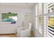 Bright bedroom with shuttered windows providing natural light and a peek at the tropical landscape at 7155 Boca Grove Pl # 102, Lakewood Ranch, FL 34202
