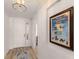 Bright entryway with wood-look floors, modern light fixture, and decorative artwork at 7155 Boca Grove Pl # 102, Lakewood Ranch, FL 34202