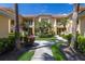 Inviting condo exterior with well-maintained landscaping, tiled roof, and walkway leading to the entrance at 7155 Boca Grove Pl # 102, Lakewood Ranch, FL 34202