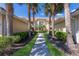 Condo exterior featuring palm trees and landscaping along the walkway to the entrance at 7155 Boca Grove Pl # 102, Lakewood Ranch, FL 34202