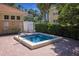 Inviting hot tub surrounded by brick pavers, lush landscaping and nearby buildings at 7155 Boca Grove Pl # 102, Lakewood Ranch, FL 34202