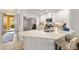 Bright modern kitchen with white cabinets, stainless steel appliances, and ample counter space with breakfast bar at 7155 Boca Grove Pl # 102, Lakewood Ranch, FL 34202