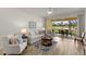 Cozy living area features an outdoor view and is furnished with a plush sofa and two armchairs at 7155 Boca Grove Pl # 102, Lakewood Ranch, FL 34202