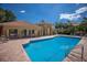 Beautiful community pool surrounded by lounge chairs, nearby buildings, and lush palm trees at 7155 Boca Grove Pl # 102, Lakewood Ranch, FL 34202