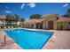 Community pool surrounded by lounge chairs, nearby buildings, and lush palm trees at 7155 Boca Grove Pl # 102, Lakewood Ranch, FL 34202