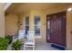 Cozy front porch featuring rocking chairs, a front door, and a welcoming exterior at 7155 Boca Grove Pl # 102, Lakewood Ranch, FL 34202