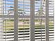 Golf course view framed by elegant shuttered windows, bringing the outdoors in at 7155 Boca Grove Pl # 102, Lakewood Ranch, FL 34202