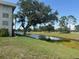 Exterior view overlooking a lake and golf course, lush lawns and mature trees at 7461 W Country Club N Dr # 201, Sarasota, FL 34243