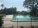Community swimming pool with lounge chairs and lush green trees at 7461 W Country Club N Dr # 201, Sarasota, FL 34243