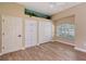 Open bedroom with vaulted ceiling, hard wood floors, large window and built in storage at 7805 Allen Robertson Pl, Sarasota, FL 34240