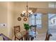 Cozy breakfast nook with a chandelier and view of the pool and lanai area through a large window at 7805 Allen Robertson Pl, Sarasota, FL 34240