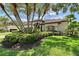 Charming single-story home featuring lush tropical landscaping, mature trees, and manicured lawn at 7805 Allen Robertson Pl, Sarasota, FL 34240