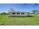 Well-maintained backyard features a green lawn, shrubbery, and a peaceful ambiance at 80 Liles St, Terra Ceia, FL 34250