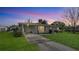Charming single-story home with lush lawn and covered driveway under a pastel sunset sky at 80 Liles St, Terra Ceia, FL 34250