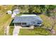 Charming home featuring a well-maintained lawn, flower beds, driveway, and a detached garage, creating curb appeal at 80 Liles St, Terra Ceia, FL 34250