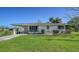 Lovely single-story home with a green lawn, covered parking, manicured shrubs, and a clean, welcoming facade at 80 Liles St, Terra Ceia, FL 34250