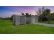 The property featuring two storage outbuildings with durable siding and driveways, situated on a well-maintained green lawn at 80 Liles St, Terra Ceia, FL 34250