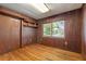 Bedroom with wood paneling, wood floors, a window, and shelving at 815 31St W Ave, Palmetto, FL 34221