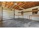 Spacious garage featuring an automatic door opener, work benches and exposed wood ceiling beams at 815 31St W Ave, Palmetto, FL 34221
