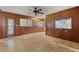 Spacious living room with wood paneled walls, tiled floors, ceiling fan, and natural light at 815 31St W Ave, Palmetto, FL 34221