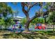 Playground with a variety of colorful equipment including slides, climbing structures, and a large tree at 815 31St W Ave, Palmetto, FL 34221
