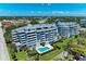 Aerial view of modern condo buildings with a pool, lush greenery, and parking, offering luxury living at 1000 Riverside Dr # B202, Palmetto, FL 34221