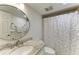 Well-lit bathroom with a round mirror, granite countertop, and a shower with a decorative shower curtain at 1000 Riverside Dr # B202, Palmetto, FL 34221