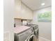 Efficient laundry room with modern washer and dryer, upper cabinets, and a bright overhead light at 1000 Riverside Dr # B202, Palmetto, FL 34221