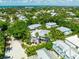 Aerial view of a neighborhood showcasing a three-story home with lush, tropical landscaping at 103 Park Ave, Anna Maria, FL 34216