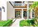Covered entryway featuring white columns, a gated garden, and double glass doors at 103 Park Ave, Anna Maria, FL 34216