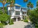 Elegant home with lush tropical landscaping and a brick driveway at 103 Park Ave, Anna Maria, FL 34216
