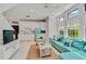 Bright and airy living space features white cabinetry, a unique blue fridge, modern décor and tons of natural light at 103 Park Ave, Anna Maria, FL 34216