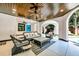 Open-air outdoor living room with ceiling fan, wicker chairs, and pool access at 103 Park Ave, Anna Maria, FL 34216