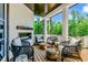 Outdoor porch featuring a fireplace, wicker chairs, and decorative ottomans at 103 Park Ave, Anna Maria, FL 34216