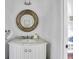 Bright powder room featuring a marble countertop vanity, ornate mirror, and stylish fixtures and decorations at 103 Park Ave, Anna Maria, FL 34216