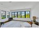 Bright sitting room offers hardwood floors, large windows with outdoor views, and comfortable seating at 103 Park Ave, Anna Maria, FL 34216