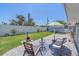 The backyard offers a patio area with outdoor seating and a well maintained lawn at 130 E Seminole Dr, Venice, FL 34293