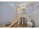 The bathroom has wood look tile floors, a pedestal sink, floral shower curtain and tiled walls at 130 E Seminole Dr, Venice, FL 34293