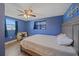 Bedroom features a dark blue accent wall, ceiling fan and wood-look tile floors at 130 E Seminole Dr, Venice, FL 34293