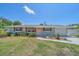 Charming single-story home with light blue exterior, wood shutters, peach-colored door, and landscaped front yard at 130 E Seminole Dr, Venice, FL 34293