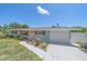 Charming single story home featuring a well-manicured lawn, flower beds, and a one-car garage at 130 E Seminole Dr, Venice, FL 34293