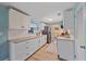 Modern kitchen boasting white cabinets, granite counters, stainless steel appliances, and wood-look flooring at 130 E Seminole Dr, Venice, FL 34293