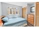 Comfortable bedroom with a blue bed, dresser, and a window that has plenty of natural light at 1307 41St E Ave, Ellenton, FL 34222